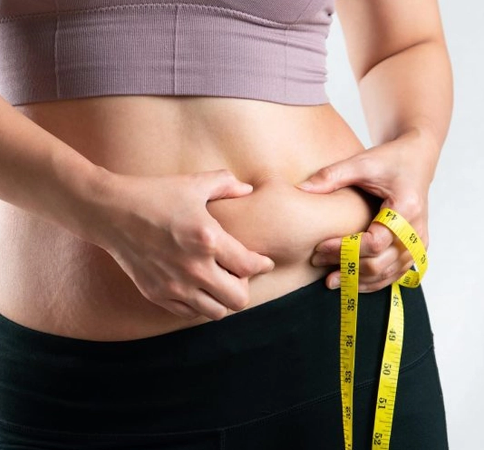 Woman measuring belly fat reduction — SlimTide natural weight loss supplement results